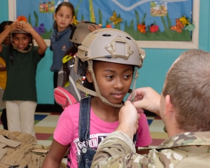 160421-N-NW169-043 SAN ANTONIO (April 21, 2016) Explosive Ordnance Disposal Technician 2nd Class Seth Willey, right, assigned to Explosive Ordnance Disposal Mobile Unit (EODMU) 11, helps kids at the Boys & Girls Clubs of San Antonio don kevlar vests and helmets during San Antonio's Navy Week. The Navy Week program is designed to raise awareness about the Navy in areas across the country that traditionally do not have a naval presence, and to bring America's Navy closer to the people it protects through community relations projects, speaking engagements, science, technology, engineering, mathematics (STEM) demonstrations and media interviews with flag hosts and local area Sailors. (U.S. Navy photo by Chief Mass Communication Specialist Michael O’Day/Released)