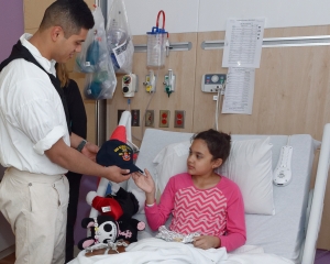 160422-N-NW169-005 SAN ANTONIO (April 22, 2016) Seaman Jaydee Rico, assigned to USS Constitution, presents a Navy command ball cap to a patient at Children's Hospital of San Antonio during a Caps for Kids visit. The Sailors from Old Ironsides are participating in San Antonio’s Navy Week. The Navy Week program is designed to raise awareness about the Navy in areas across the country that traditionally do not have a naval presence, and to bring America's Navy closer to the people it protects through community relations projects, speaking engagements, science, technology, engineering, mathematics (STEM) demonstrations and media interviews with flag hosts and local area Sailors. (U.S. Navy photo by Chief Mass Communication Specialist Michael O’Day/Released)
